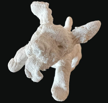 Small sculpture of a happy dog presents an intriguing blend of form and texture that invites analysis from multiple perspectives