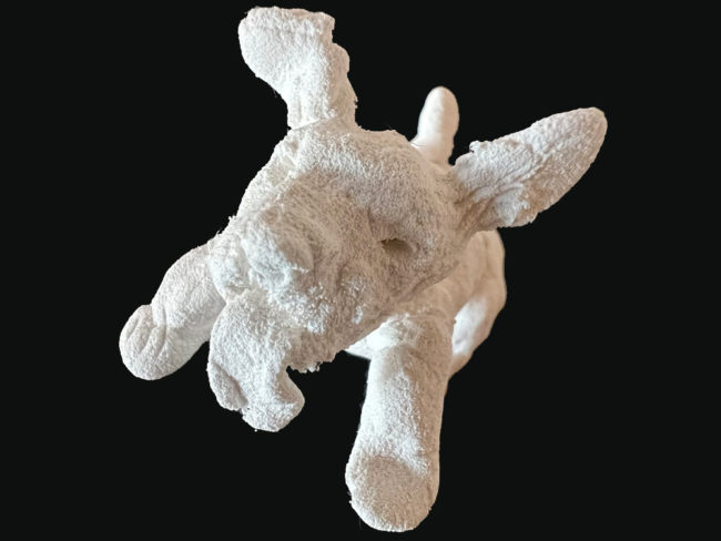 Small sculpture of a happy dog presents an intriguing blend of form and texture that invites analysis from multiple perspectives